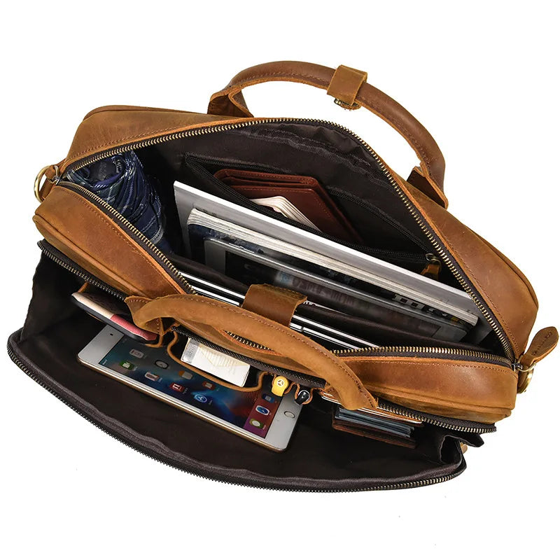 A brown vintage genuine leather briefcase with a zipper and padded interior holding various documents and a tablet.