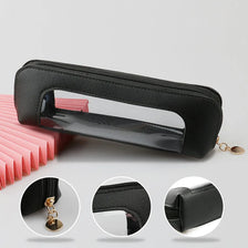 Pochette d'organisation cosmétique portable noire avec fenêtre transparente et détail de chaîne dorée.