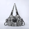 A black and white leopard print vintage PU leather hobo shoulder bag with a flap closure.