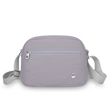 A light purple nylon crossbody bag with a flap closure and adjustable strap is shown against a white background.