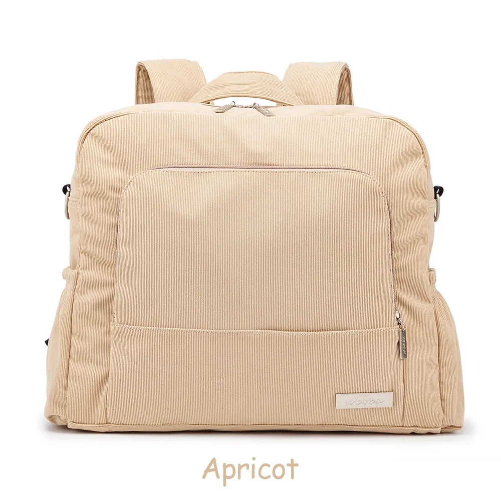 A beige soft corduroy diaper backpack designed for mothers.