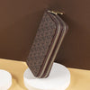 A brown patterned PU leather zippered wallet is displayed on a white circular stand against a dark background.