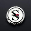 Silver metal letter S with floral accents on a round hook for accessories