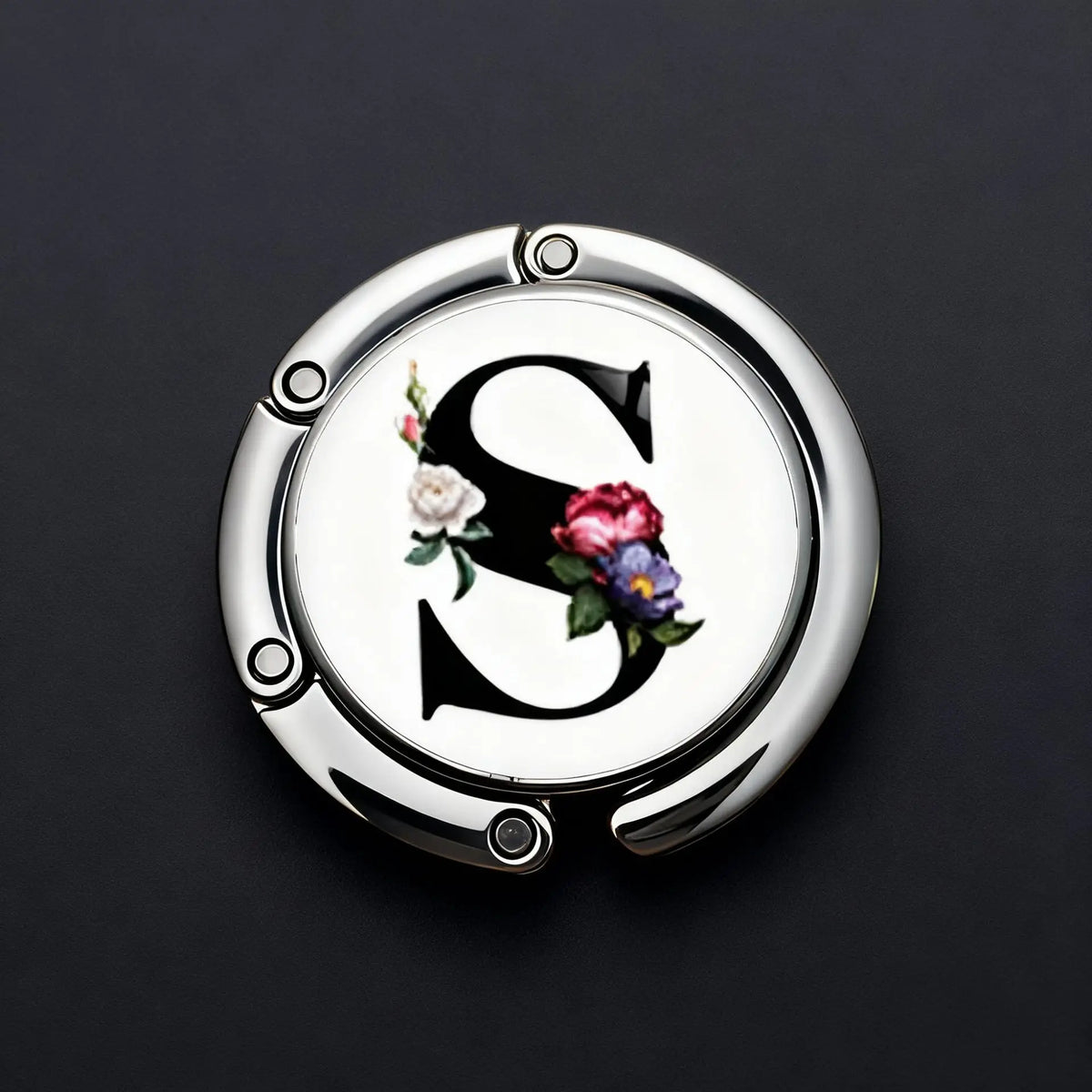 Silver metal letter S with floral accents on a round hook for accessories
