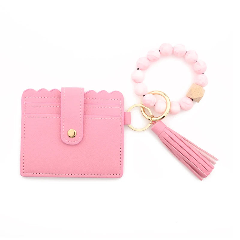 Pink silicone bead bracelet attached to a pink leather card holder.