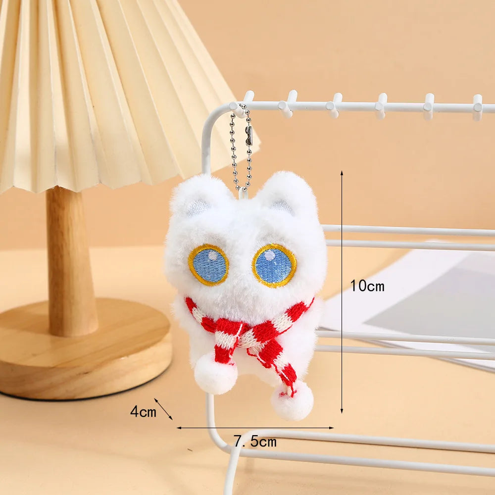 A white fluffy cat plush charm hanging from a silver wire keychain against a light background.