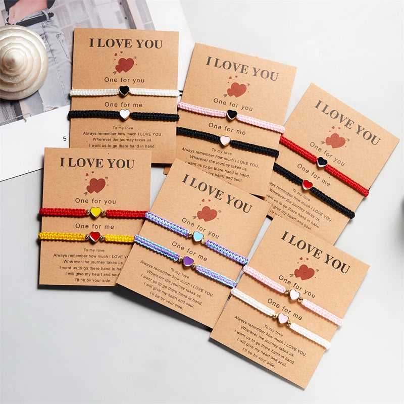 A collection of five heart-shaped beaded friendship bracelets in various colors and pink tones displayed on a white surface.