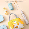 A yellow insulated thermal picnic lunch bag with a bear face is shown next to various picnic items and a water bottle.