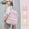 A young woman is holding a pink Oxford school backpack and several variations of the same backpack in different colors.