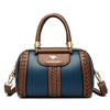 A brown and navy leather shoulder bag with a woven pattern and gold hardware.