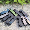 Collection de porte-clés organisateurs en métal minimalistes de différentes couleurs et finitions posés sur une pierre claire