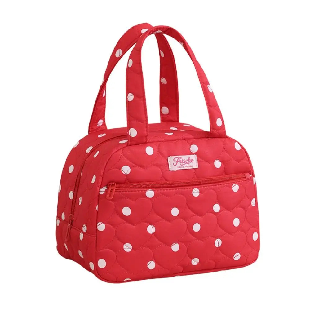 A red insulated lunch tote bag with a quilted pattern and white polka dots.