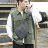 A young man wearing a olive green vest over a white shirt, holding an anti-theft crossbody chest bag.