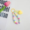 A colorful bead necklace featuring pink, yellow, and green beads with a heart charm on a gold-colored O-ring clip.