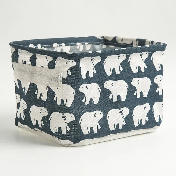 A dark blue fabric storage basket with white bear print and handles.