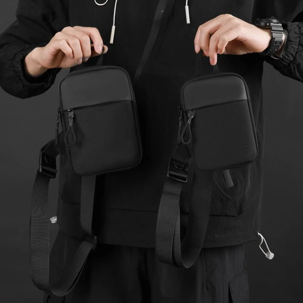 A person is holding a black Oxford chest bag with a strap, designed as a lightweight travel phone pouch.