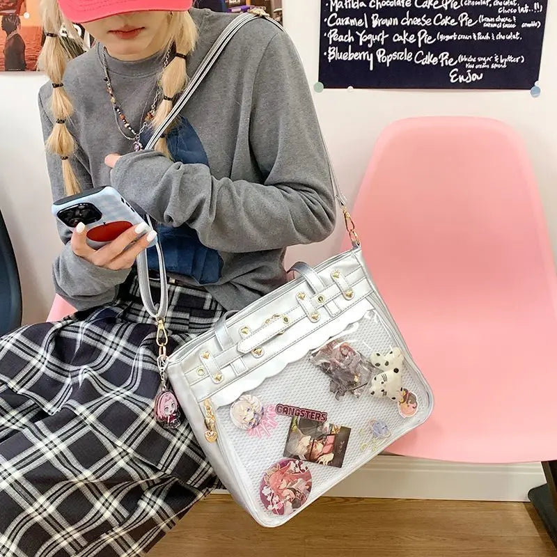 A person wearing a gray sweater and plaid skirt holds a white Y2K punk goth crossbody bag.