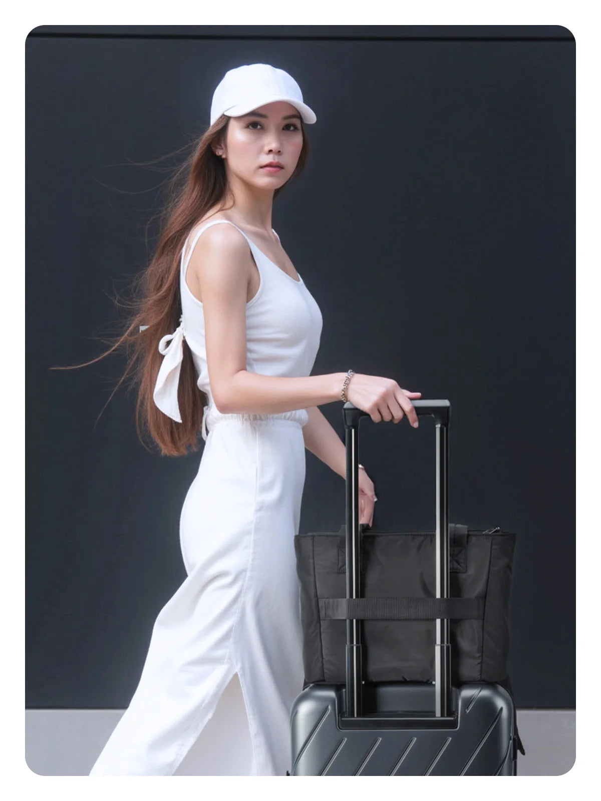 Une femme vêtue de blanc tient un sac à main noir matelassé et rembourré.