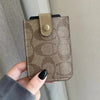 A close-up shot of a brown patterned PU leather card holder purse with a leather strap being held by a hand.