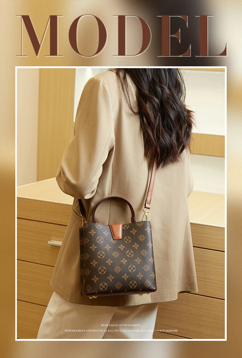 A beige coat features a brown leather bucket bag with a gold-toned strap and a patterned design.