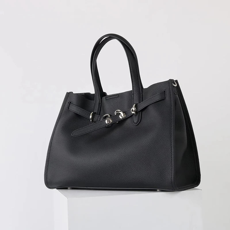 A black genuine leather women's shoulder tote bag with a top handle shown from the front.