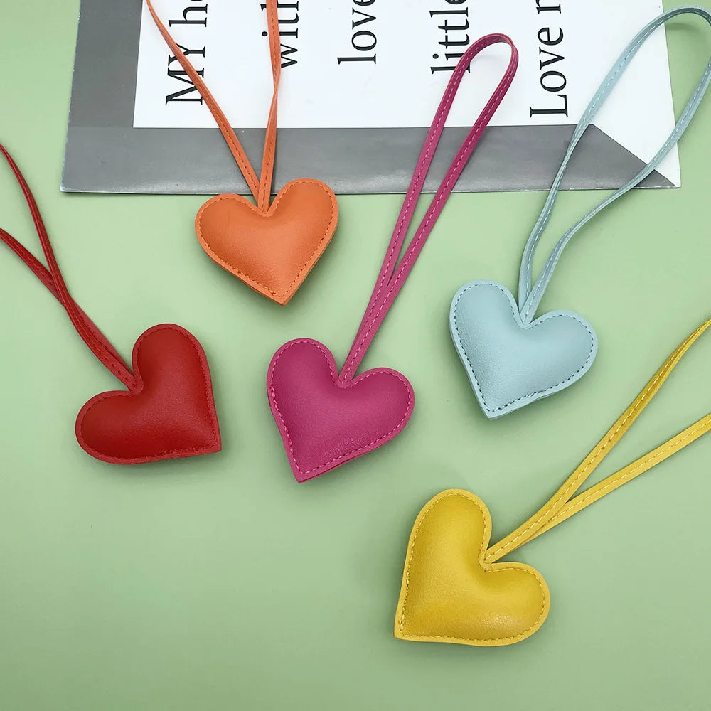 A collection of five heart-shaped PU leather keychains in various colors including orange, pink, red, purple, and light blue 