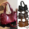 A maroon leather shoulder bag with a strap and chain detail is shown in a close-up view.