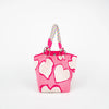 A pink tote bag with a heart print and a multicolored striped rope handle.