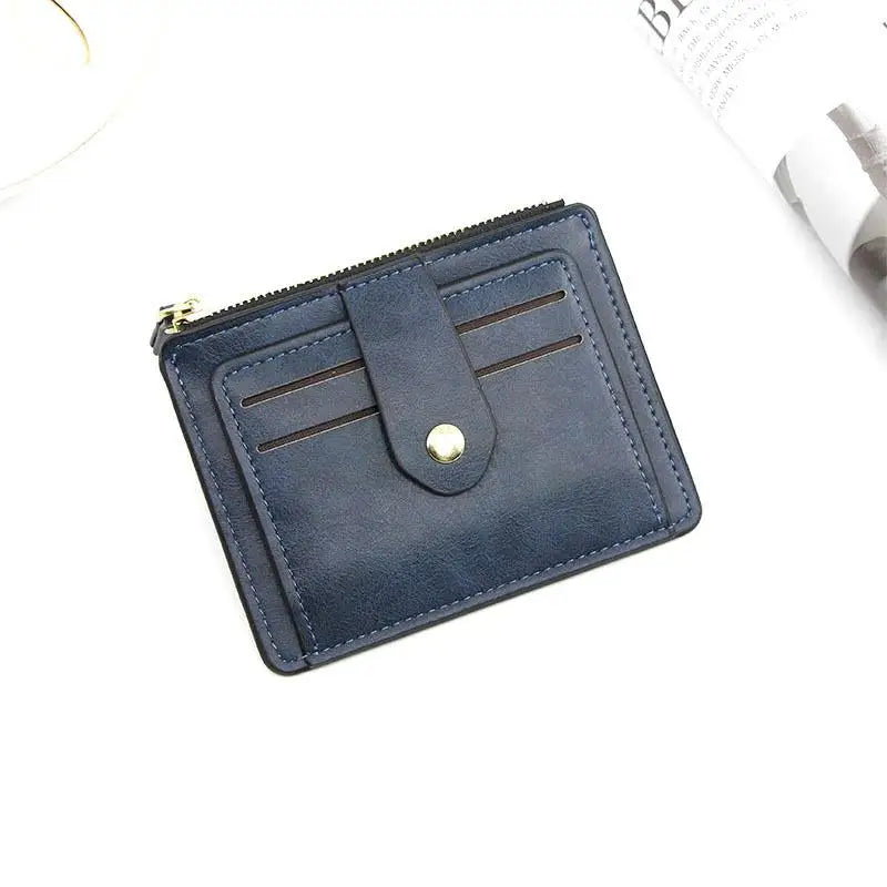 A dark blue leather card holder wallet with a zipper and coin pocket shown from above.