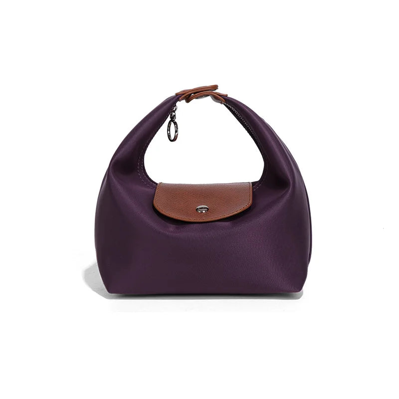 A deep purple waterproof nylon crossbody bag with a brown leather flap and dual straps.