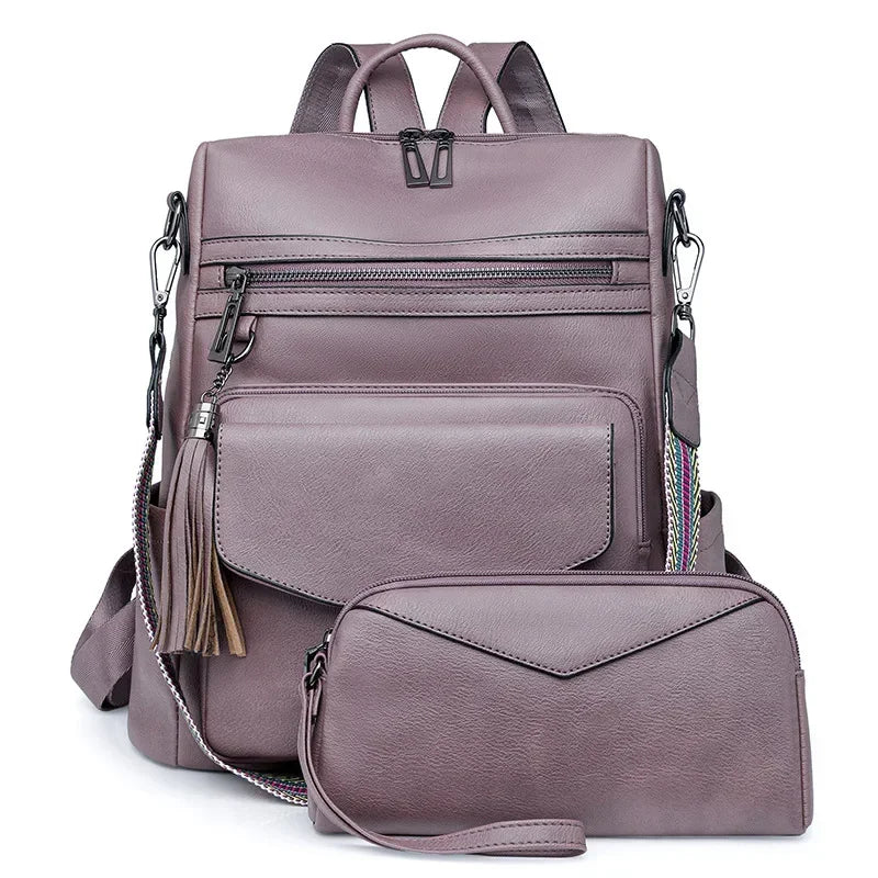 A mauve retro PU leather travel backpack featuring zippered compartments and a tassel detail.