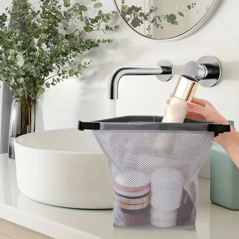 Un robinet en acier inoxydable au-dessus d'un évier blanc, avec un sac de rangement à cordon placé dans la cuve.