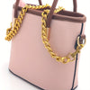 A light pink leather purse with a gold chain strap and brown leather handles.