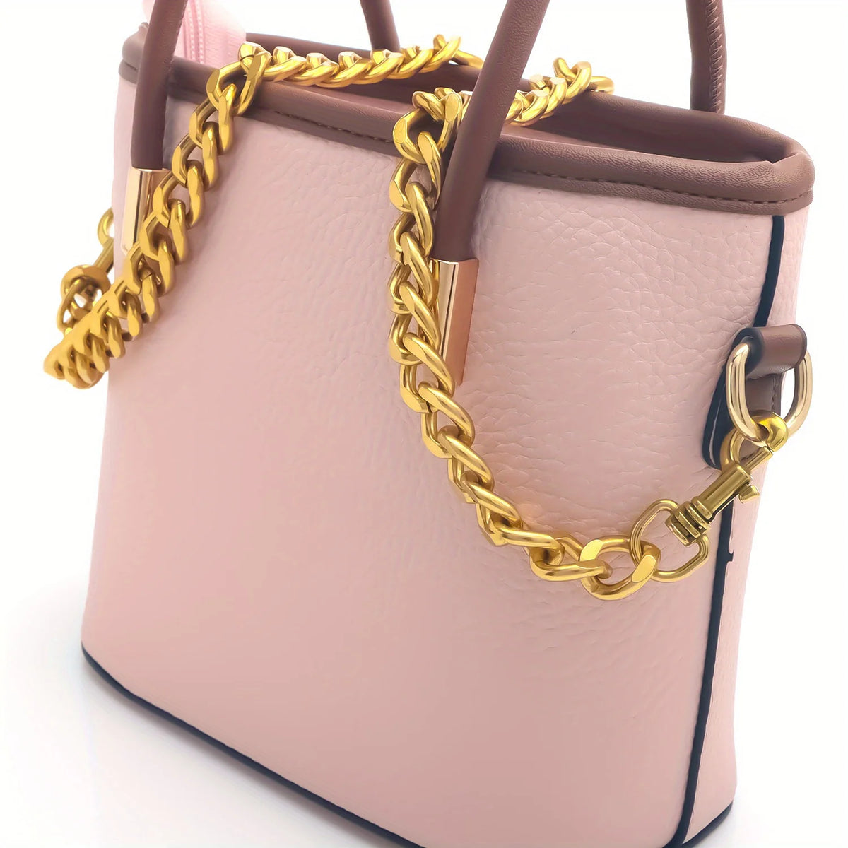 A light pink leather purse with a gold chain strap and brown leather handles.