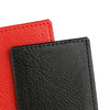 A close-up of two PU leather luggage tags, one red and one black, showing the texture of the material.