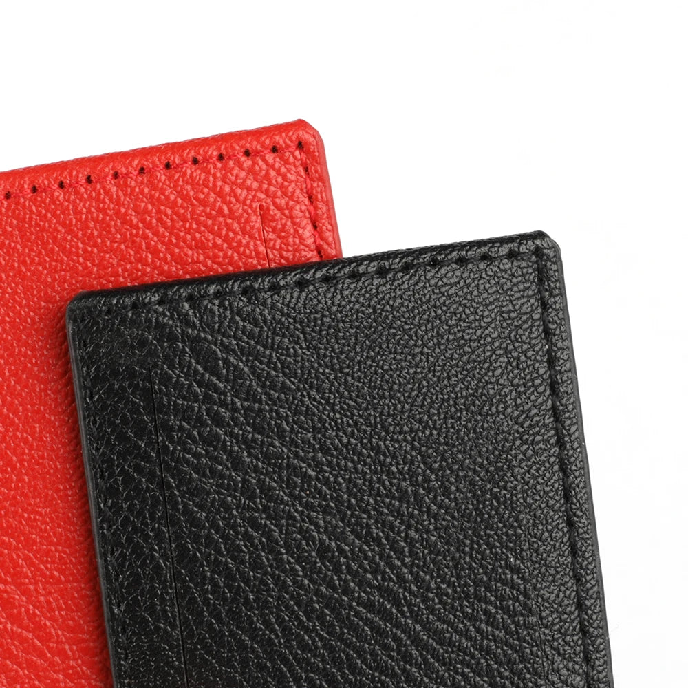 A close-up of two PU leather luggage tags, one red and one black, showing the texture of the material.