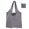 A black and white striped nylon reusable tote bag shown in a vertical orientation.