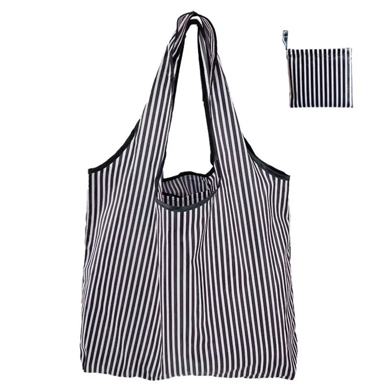 A black and white striped nylon reusable tote bag shown in a vertical orientation.