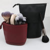 A black makeup brush storage case with a separate red pouch containing various makeup brushes.