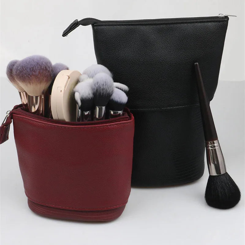 A black makeup brush storage case with a separate red pouch containing various makeup brushes.