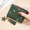 A dark green compact PU leather wallet with a zipper closure decorated with small pink and white heart shapes and a gold tass