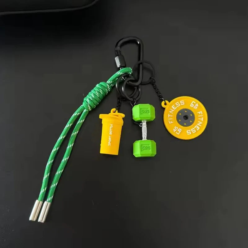 A green nylon D-shape fitness keychain with various colored weights and a yellow fitness tag.