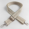 A beige woven handbag strap with an arrow jacquard pattern, shown in an 'X' shape.