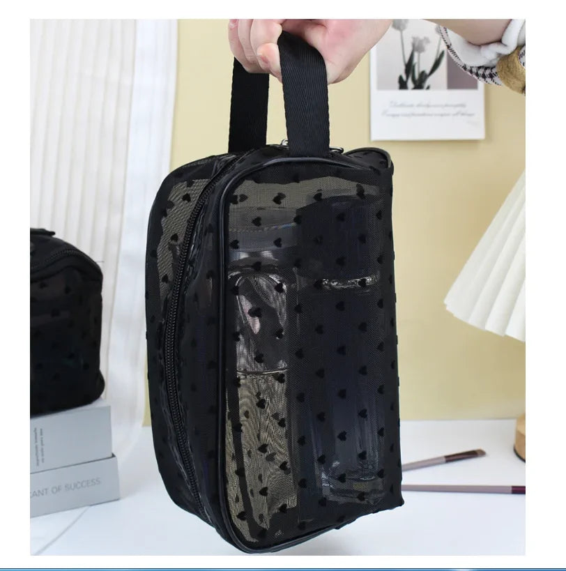 A black mesh transparent makeup storage bag with a black strap is shown against a light background.