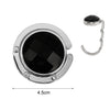 Silver round acrylic foldable hook with a black opening for bags and keys