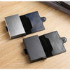 A black leather double layer ID card holder wallet shown open on a wooden surface.