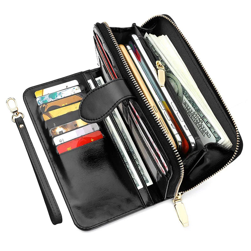 A black wax leather long wallet with a zipper and wrist strap, showing various cards and cash inside.