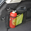 A red bottle is stored in a black mesh bag inside a car trunk organizer net.
