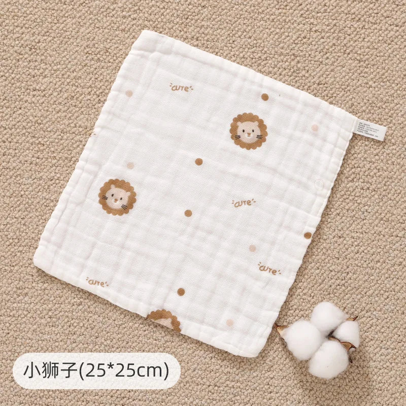 White muslin baby burp cloth towel with lion embroidery on a beige background