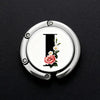 Silver foldable letter Hanger hook with a pink rose design on a black background.